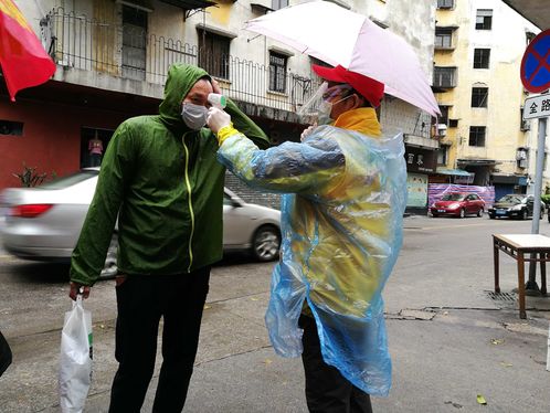 中山民进会员苏涌智在街头给市民测体温.jpg